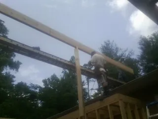 Carpenter setting a ridge beam over a new addition frame — Ice Dam Removal by Roofing Brothers in Blue Ridge