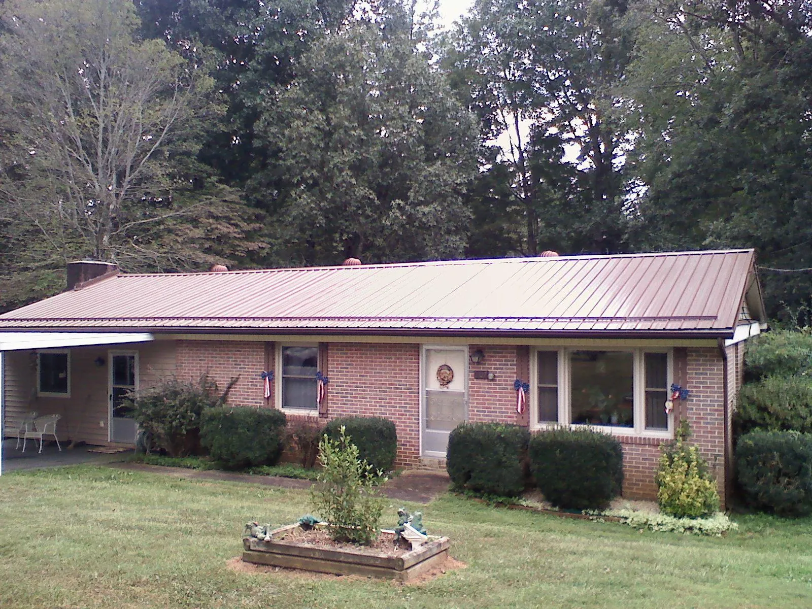 Bronze metal roof on a brick ranch home with a carport in Blue Ridge